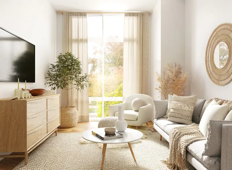 A bright, calm sitting room with soft furnishings and daylight through a large window.